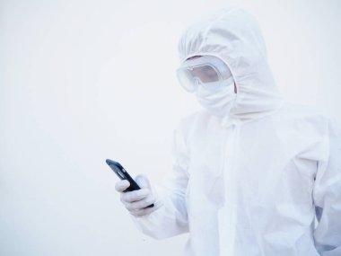 Aile ya da Freind ile sohbet etmek için telefonuyla oynarken PPE süit üniformalı genç doktor ya da bilim adamı. Coronavirus veya COVID-19 kavramı izole edilmiş beyaz arkaplan