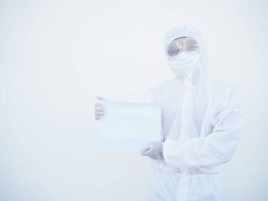PPE süit üniformalı genç bir doktor ya da bilim adamı iki eliyle önlerine bakarken boş kağıt tutuyorlar. Coronavirus veya COVID-19 kavramı izole edilmiş beyaz arkaplan