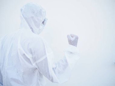 Başarılı duygusal Asyalı doktor ya da PPE süit üniformalı bilim adamı geleceğe bakarken. Zevkle yumruklarını sıkar, mutlulukla, zaferini kutlar, büyük bir zafer kazanır. Coronavirus veya COVID-19 kavramı izole edilmiş beyaz arkaplan