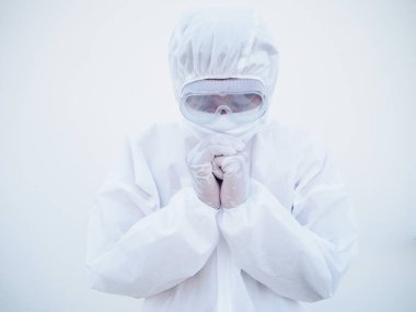 PPE süit üniformalı Asyalı erkek doktor veya bilim adamının yakın çekimleri, koronavirüs salgını veya COVID-19 izole beyaz arka plan salgını sırasında stres ve dua içeriyor. 