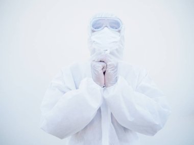 PPE süit üniformalı Asyalı erkek doktor veya bilim adamının yakın çekimleri, koronavirüs salgını veya COVID-19 izole beyaz arka plan salgını sırasında stres ve dua içeriyor. 