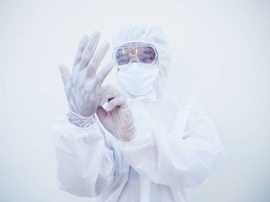PPE süit üniformalı Asyalı doktor ya da bilim adamı ellere bakarken koruyucu beyaz eldivenler giyiyor. COVID-19 kavramı izole edilmiş beyaz arkaplan