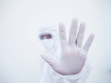 PPE süit üniformalı Asyalı erkek doktor ya da bilim adamı geleceğe bakarken dur işareti gösteriyor. Coronavirus veya COVID-19 kavramı izole edilmiş beyaz arkaplan