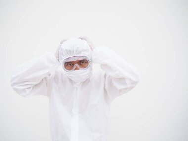 PPE süit üniformalı Asyalı erkek doktor ya da bilim adamı elini baş ağrısı ve kırışıklık hissi ile kafasına koyuyor. Coronavirus veya COVID-19 kavramı izole edilmiş beyaz arkaplan