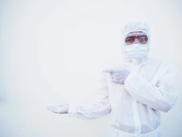 Asian male doctor or scientist in PPE suite uniform showing pointing fingers away at copy space while standing and looking forward. coronavirus or COVID-19 concept isolated white background