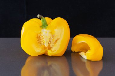 Koyu bir arka planda olgun sarı dolma biber. Dilimlenmiş sarı dolma biber. C vitamini kavramı