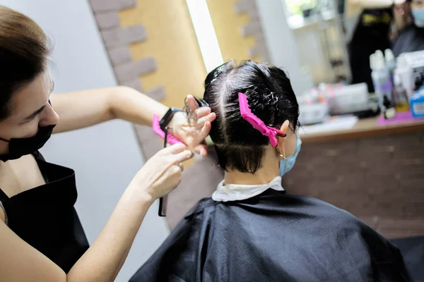 在验尸期间理发服务 戴口罩的理发师用口罩剪女人的头发 Covid 19期间理发的理发师 — 图库照片