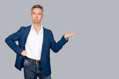 Çekici adam avuçlarını açık tutuyor. İş adamı açık elle sunum yapıyor. İzole edilmiş gri arka plan. Boşluğu kopyala