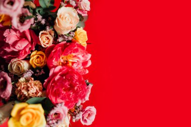 Kırmızı arka planda renkli çiçekleri olan güzel bir buket.