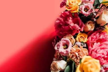 Kırmızı arka planda renkli çiçekleri olan güzel bir buket.