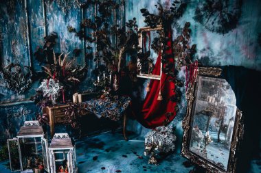 Kurumuş çiçekler, vazolar, avizeler, altın çerçeveli kumaşlar, lüks kraliyet tarzı ahşap bir masa, eski fenerlerle yanan mumlar.