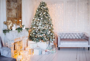Noel ağacı ve dekoratif şömineyle süslenmiş, zarif, aydınlık renkte bir oda tasarımı.