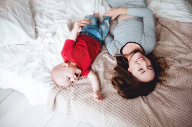 Mutlu anne ve bebek evde yatakta.