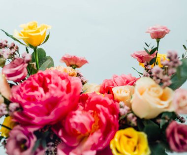 Mavi arka planda renkli güller olan güzel bir buket.