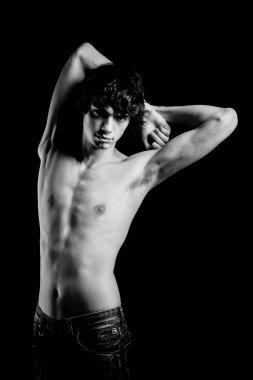 Üstsüz, baştan çıkarıcı yakışıklı model stüdyoda poz veriyor.