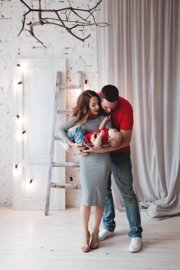 Stüdyoda bebekle poz veren mutlu ebeveynler.