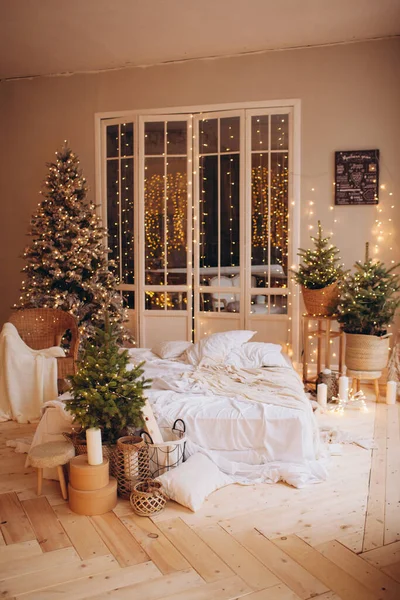 cozy light room with a mattress bed in Christmas style design and xmas tree