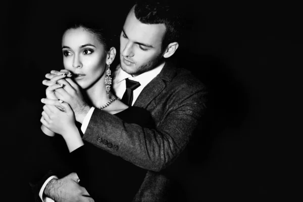 Çekici bir çift şık kıyafetler giyip geceleri dışarıda sarılıyorlar. 