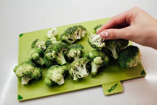 Tangan Wanita Mengambil Brokoli Hijau Segar Dari Pemotongan Papan — Stok Foto