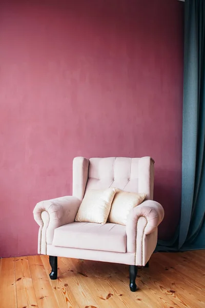 old white armchair in vintage style with red wall