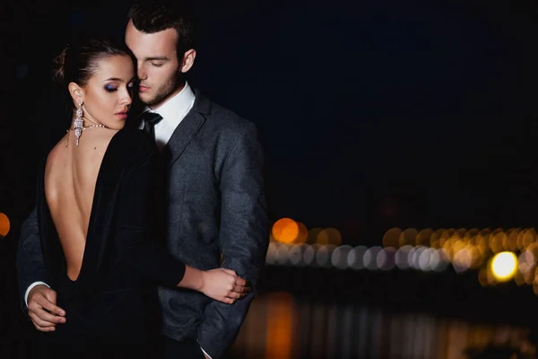 迷人的一对穿着时髦服装的情侣在夜晚拥抱着外面 — 图库照片