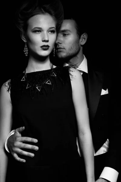 Güzel, tutkulu bir çift koridorda dikiliyor, bir adam bir kadına arkadan sarılıyor.