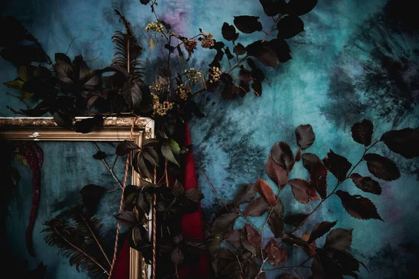 Kurumuş çiçekler, vazolar, avizeler, altın çerçeveli kumaşlar, lüks kraliyet tarzı ahşap bir masa, eski fenerlerle yanan mumlar.