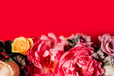 Kırmızı arka planda renkli çiçekleri olan güzel bir buket.