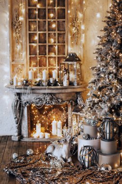 Noel iç tasarımında sıcak ve sıcak bir akşam, ışıklarla süslenmiş Xmas ağacı hediyeler, oyuncaklar, geyikler, mumlar, fenerler, kapalı alanda yanan çelenkler.