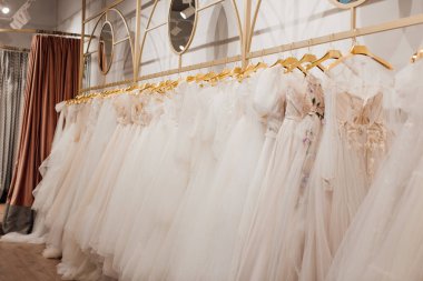 Mağazadaki askılarda asılı güzel beyaz gelinlikler