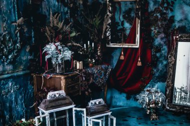 Kurumuş çiçekler, vazolar, avizeler, altın çerçeveli kumaşlar, lüks kraliyet tarzı ahşap bir masa, eski fenerlerle yanan mumlar.