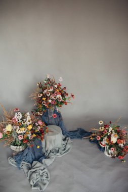 Kurumuş çiçekli renkli buketler gri kumaş arka planda