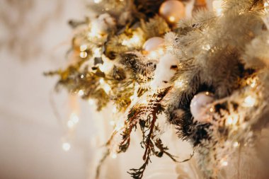 Noel ağacındaki klasik Noel ağacı oyuncaklarının yakın plan fotoğrafı. Altın rengi süslemeler, çelenk ışıkları. Mutlu yıllar ve Noel