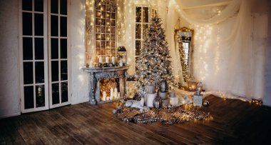 Noel odasında sıcak ve sıcak bir akşam, iç tasarım, ışıklarla süslenmiş Noel ağacı, oturma odası. Yeni yılda sihir.