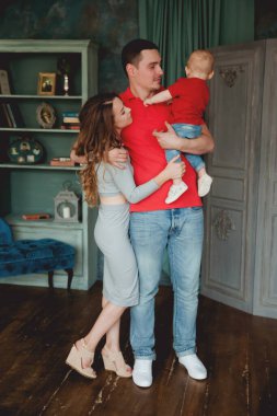 Stüdyoda bebekle poz veren mutlu ebeveynler.