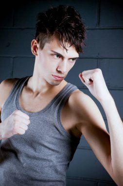 Stüdyoda boks pozisyonu almış yakışıklı bir model.