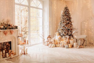 Noel iç tasarımında sıcak ve rahat bir sabah, ışıklarla süslenmiş Xmas ağacı hediyeler, oyuncaklar, geyikler, mumlar, fenerler, çelenkler, şöminenin içinde.