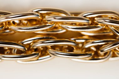 Beyaz arka planda büyük altın örgülü zincir bileziğin yakın çekim görüntüsü