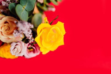 Kırmızı arka planda renkli çiçekleri olan güzel bir buket.