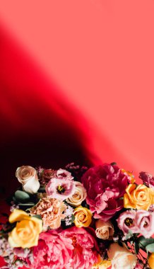 Kırmızı arka planda renkli çiçekleri olan güzel bir buket.