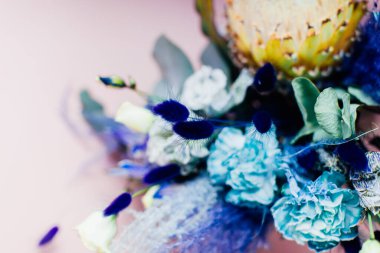 Pembe arka planda mavi çiçekli güzel bir buket.