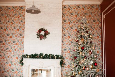 Noel ağacı, hediyeler, şömine ve çelenklerle süslü bir iç dizayn.