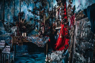 Kurumuş çiçekler, vazolar, avizeler, altın çerçeveli kumaşlar, lüks kraliyet tarzı ahşap bir masa, eski fenerlerle yanan mumlar.