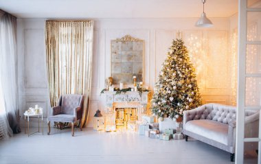 Noel ağacı ve dekoratif şömineyle süslenmiş, zarif, aydınlık renkte bir oda tasarımı.
