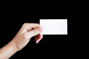 Fransız manikürlü bir kadının elinde siyah arka planda boş bir kartvizit ya da kredi kartı bulunur.
