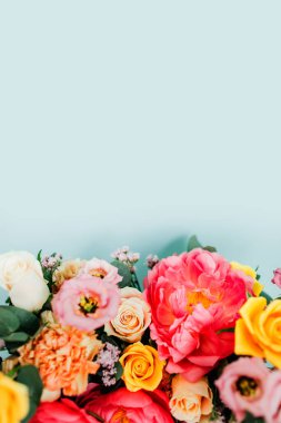 Mavi arka planda renkli güller olan güzel bir buket.