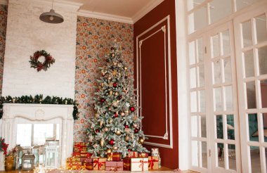 Noel ağacı, hediyeler, şömine ve çelenklerle süslü bir iç dizayn.