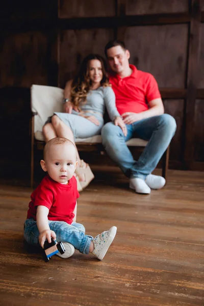 Gelukkig Ouders Poseren Met Baby Jongen Bank Studio — Stockfoto