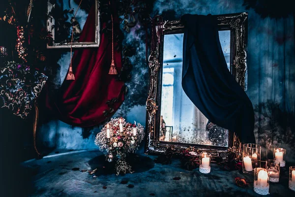 Kurumuş çiçekler, vazolar, avizeler, altın çerçeveli kumaşlar, lüks kraliyet tarzı ahşap bir masa, eski fenerlerle yanan mumlar.