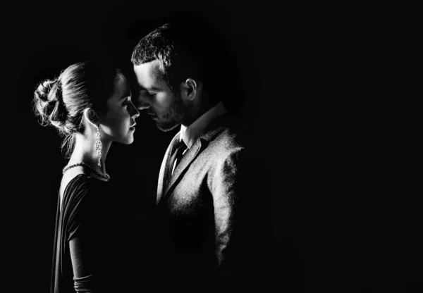 Çekici bir çift şık kıyafetler giyip geceleri dışarıda sarılıyorlar. 